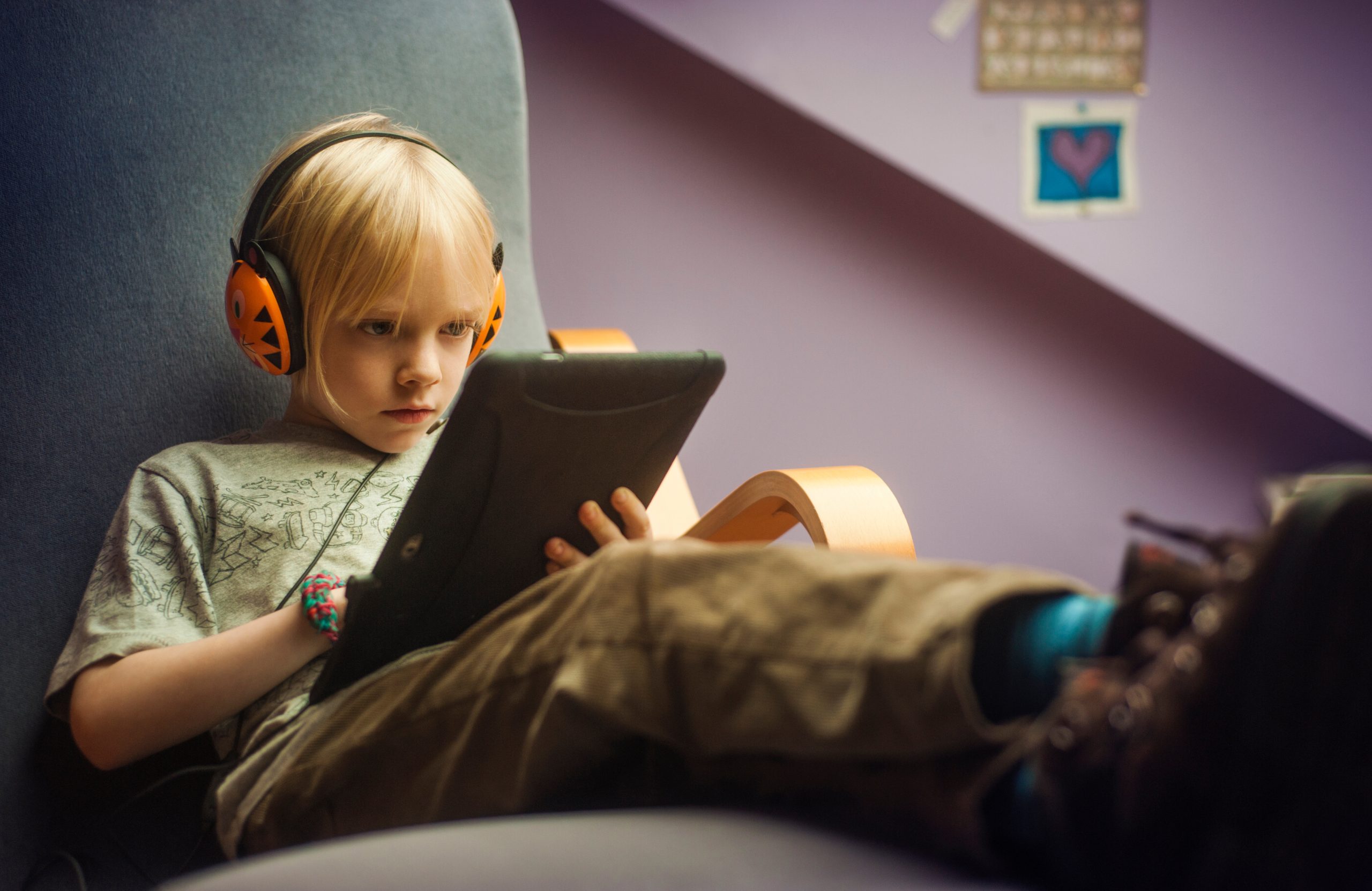Young boy listening music while using tablet computer at home