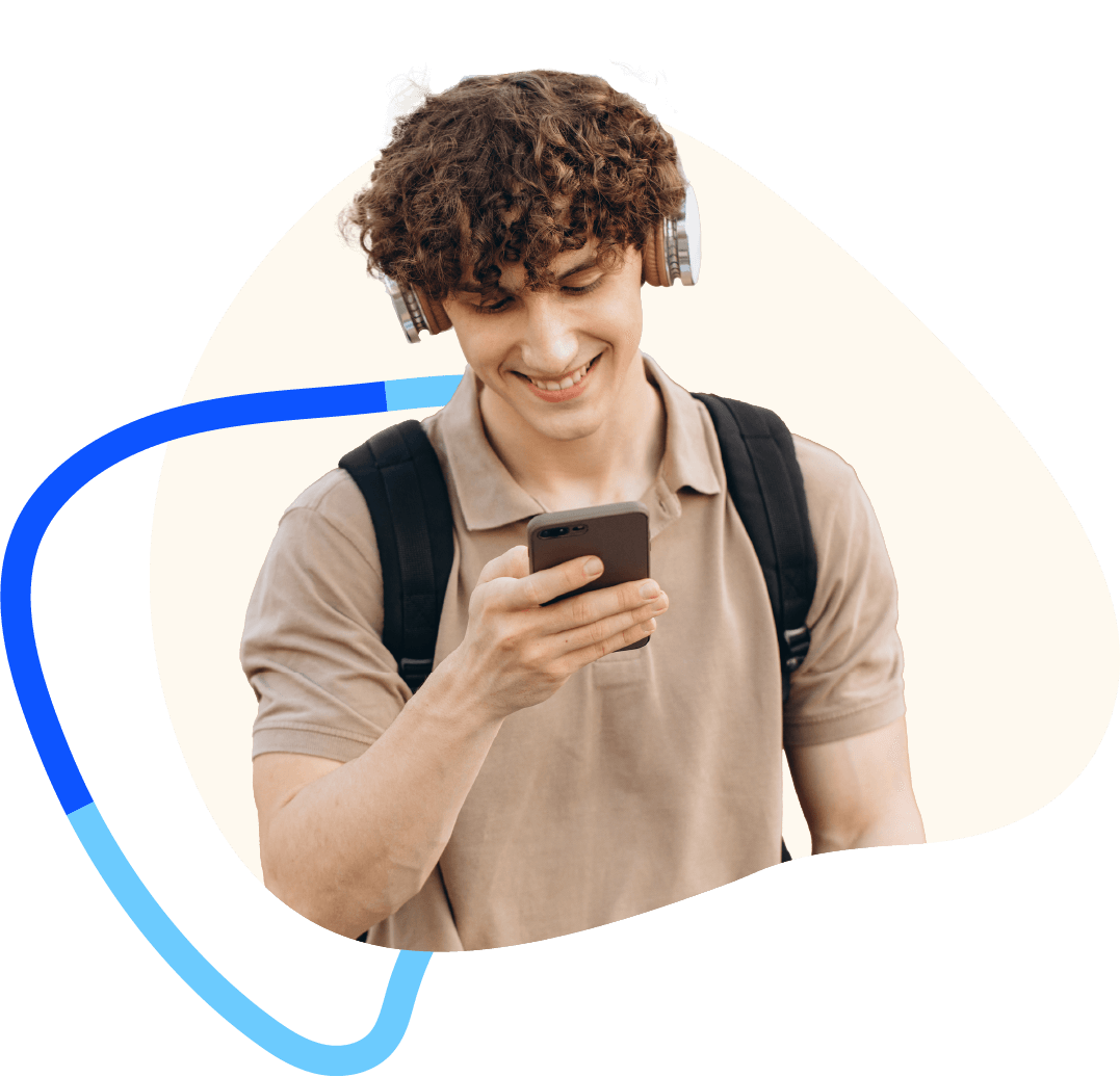 Teenager with curly hair and brown polo shirt smiling while looking at smartphone